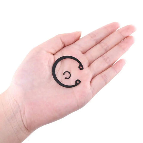 Hand holding small and large snap rings from Pro Grade Internal Snap Ring Kit Set 150 Piece Alloy Steel Retaining Clip Ring Assortment