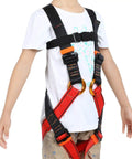 Kid wearing full body safety harness for outdoor adventures built tough for tree climbing zipline caving and rappelling fun training.