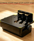 Black Adjustable Piano Pedal Extender For Students With Stabilizer Three Pedals, rounded edges, on wooden floor