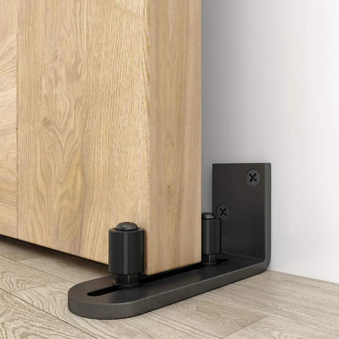Sliding Barn Door Floor Guides Adjustable Stay Roller Hardware Kit Set of 2 with Smooth Ball Bearings and Flat Bottom Design Flush With Floor Wall Mount Roller Guide for Small Space Black Sturdy Steel Bracket and Upgraded Round Corners installed on wood floor.