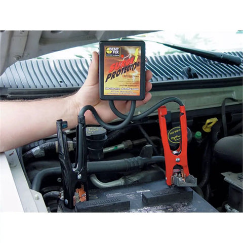 Hand holding surge protector connected to car battery with cables, Surge Protector For Vehicle Welding And Jump Start Protection
