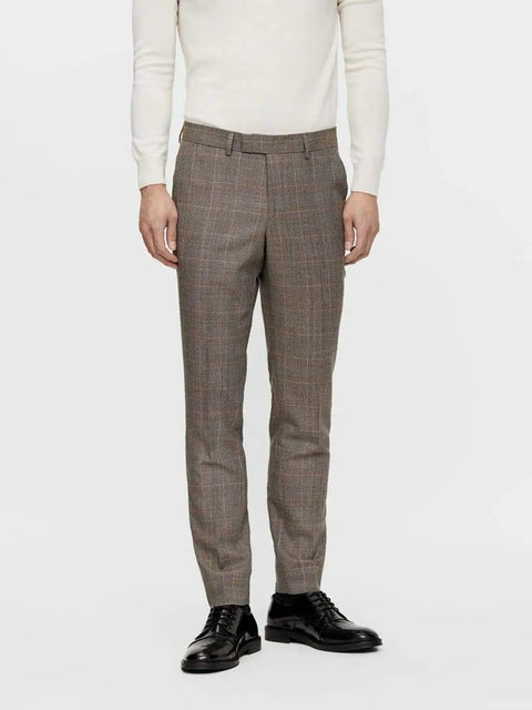 Man wearing brown plaid suit trousers and black dress shoes