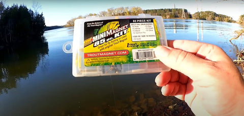 Hand holding Mini Jig Kit For Trout And All Freshwater Fish 85 Piece Set With 70 Grub Bodies And 15 Size 14 Hooks by lakeside
