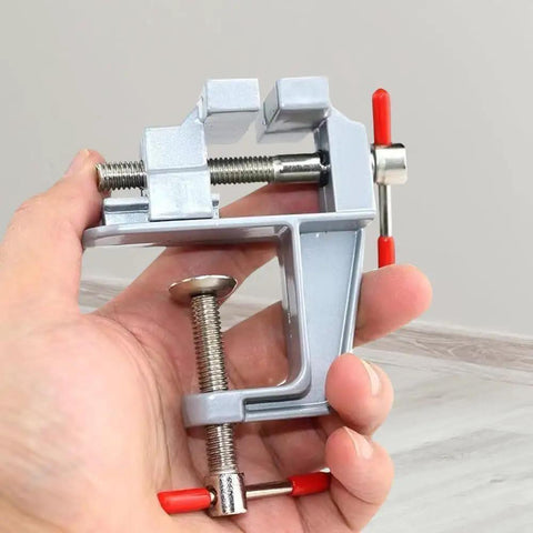 Hand holding a lightweight aluminum Compact Table Vise For DIY Projects And Home Repairs, Handy Bench Clamp For Woodworking.