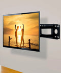 Wall-mounted television displaying sunset beach scene, supported by adjustable bracket for optimal viewing angles.