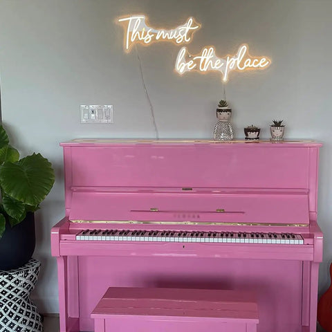 Large 43.7x8 Inch Neon Sign LED Wall Decor for Wedding Bar Office Cafe Party, glowing above pink piano with plants nearby.