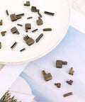 Go To Zipper Bottom Stopper Kit Set With Latch Slider Retainers And Insertion Pins For Coats Jackets And Bags Includes 4 Size Options 3 5 8 10 Bronze Metal Zipper Repair Parts For DIY Sewing Fasteners Replacement on a table