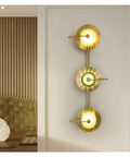 Top Shelf Modern Copper Led Wall Sconces With Warm White Glow Badass Fixture For Bedroom Living Room And Hallway Decor Anti Rust Non Flicker Eye Friendly Vibe Lighting Fixtures mounted on a wall, featuring three circular lights in gold.