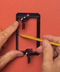 1 Gang Low Voltage Mounting Bracket Pack Of 2 Black For Retrofit Telephone Coax And Network Wall Plates Fits Quarter Inch To One Inch Wall Thickness Horizontal Or Vertical Mount Flush Mounting being marked with pencil for installation on red wall.