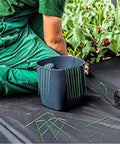 Person installing Heavy Duty Garden Ground Stakes 6 Inch U Shaped Steel Pegs For Lawn Fabric Netting Matting Pro Grade Landscape Anchors 20 Pack
