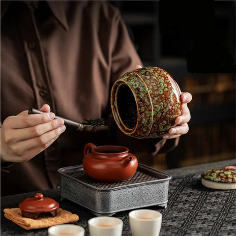 Kick Up Your Pantry Game With These Premium Ceramic Sealed Storage Jars For Loose Tea And Coffee Beans Featuring Ridiculously Tight Lids Really Cool Retro Double Bin Gift Box Organizer, user pouring tea leaves from a ceramic jar.