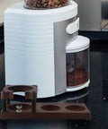 Adjustable Wooden Espresso Tamping Station And Hella Sturdy Portafilter Holder For 51 Mm Plus 58 Mm Coffee Tools positioned next to a coffee grinder.