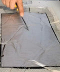 Person cutting Heavy Duty Waterproof Roofing Tape Roll For Asphalt Shingle Repair on a work surface with a utility knife.