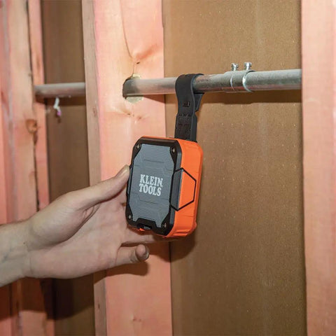 Rugged Bluetooth Speaker With Magnetic Strip And Hook attached to pipe on jobsite, emphasizing IP54 dust and water resistance.