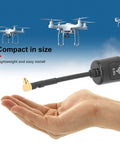 Bangin 5.8Ghz MMCX 2.8dBi RHCP high gain antenna shown on open hand with flying drones in background, compact size, easy install.
