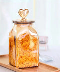 Top Shelf Durable Borosilicate Glass Jar Slick Amber Tint Secure Flip Lid Seal Keep Your Coffee Beans Spices And Dried Fruit Fresh In Style No Sweat Kitchen Pantry Organization Solution That Goes Hard with heart-shaped lid and orange cereal.