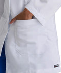 Close-up of hand in pocket of Lily White Lab Coat For Women With Natural Stretch 34 Inch 4 Pocket Scrub Coat Soil Release Fabric Finish