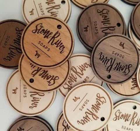 Front view of round wooden soap labels engraved with StoneRiver Soaps, each with a hanging hole.