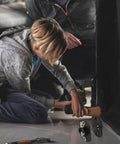 Child and adult installing Heavy Duty Sectional Sofa Connectors Twenty Pack Metal Interlocking Alligator Pins under couch.