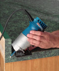 Bosch handheld router side view, blue body, 1/4 in. straight bit installed, held by hand.