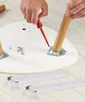 Four Pack Foldable Furniture Legs With Plastic And Iron Frame in white, being installed on a table, showing no-tool setup.