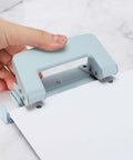 Beefy 6mm Two Hole Punch Handheld Paper Punch in use, ergonomic non-slip grip, punching paper on a marble surface