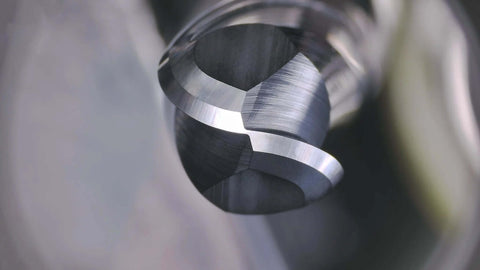 Ball-nose carbide end mill tip, close-up view of fluted cutting edge