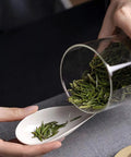 Top Notch Slick Large Glass Kitchen Jars Set Of Four Aluminum Lids with tea leaves pouring into a spoon for organized storage.