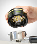 Hand holding Top Shelf 54Mm Spirographic WDT Tool Espresso Coffee Distribution above a portafilter with fine needles.