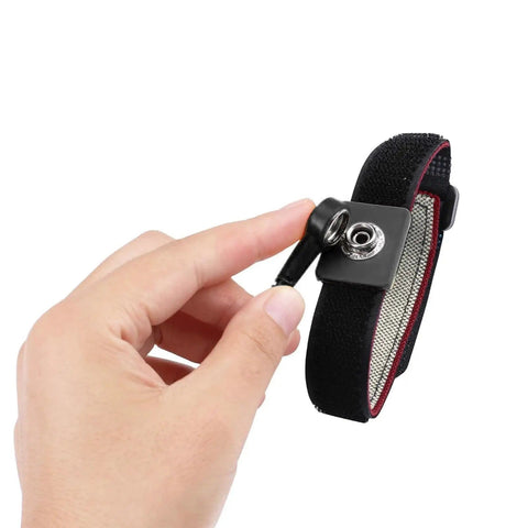 Hand holding Anti Static Wrist Strap Eleven Inch Grounding Bracelet With Alligator Clip And Extendable Cable No Fuss Adjustable Fits Wrists Six To Eight Point Five Inches Red ESD Safe For PC Repair And Electronics Assembly showcasing alligator clip.