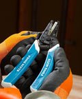 Klein Tools 56025 non-conductive fish tape repair kit with blue-handled pliers, held by gloved hands, close-up