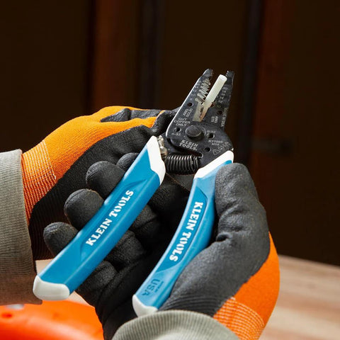 Klein Tools 56025 non-conductive fish tape repair kit with blue-handled pliers, held by gloved hands, close-up