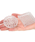 Hand holding clear plastic round and square 24 Pack Spiked Caster Cups For Furniture Protectors with studded base.