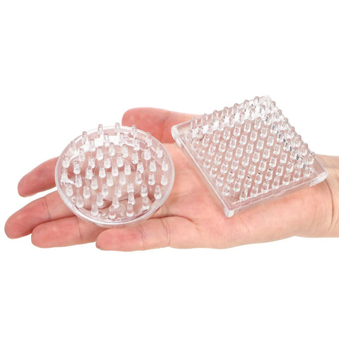 Hand holding clear plastic round and square 24 Pack Spiked Caster Cups For Furniture Protectors with studded base.