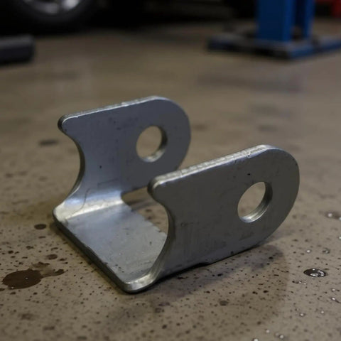 Heavy Duty Suspension Bracket Kit With Swing Arm And Control Arm Shock Mounts For Weekend Wrenching and Dirt Road Builds detailed metal bracket on workshop floor.