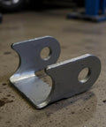Close-up of a heavy-duty metal bracket from the 6-Piece Bushing Swing Arm Bracket Kit With Shock Mount and Control Arm Hardware.