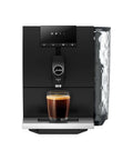 Step Up Your Home Brew Game With This Compact Automatic Coffee Machine Featuring A Pro Aroma Grinder And Super Simple Programmable Settings In Classic Metropolitan Black Color. Black espresso machine with coffee glass below.