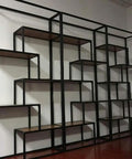Large black metal industrial shelving unit with multiple levels and wooden shelves against a wall