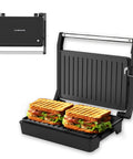 Multi Purpose Compact Contact Grill Sandwich Maker Panini Press With Floating Hinge Non Stick Plates cooking two grilled sandwiches with layers of lettuce and bacon.