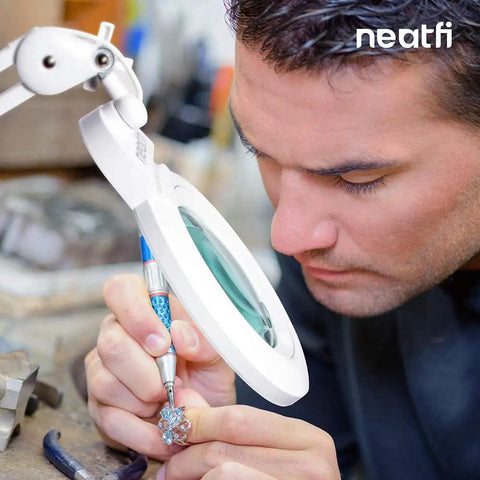 Man using XL Bifocals 1200 Lumens LED Magnifying Lamp With Clamp for detailed jewelry work at a desk.