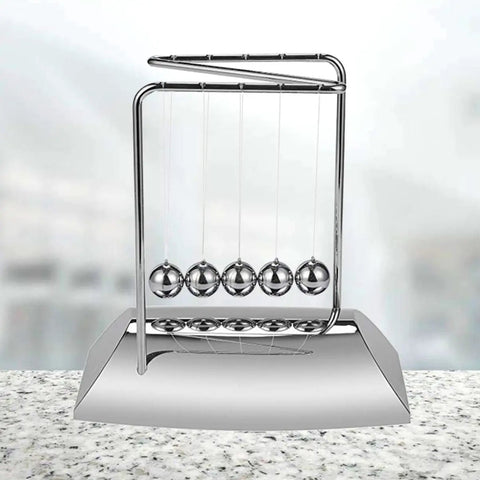 Z Shape Newton's Cradle Pendulum Balls For Learning And Home Office Decoration on a desk, five silver balls swinging.