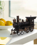 Vintage Steam Locomotive Model Sculpture for Desk Decor and Living Room on white table next to fruit bowl
