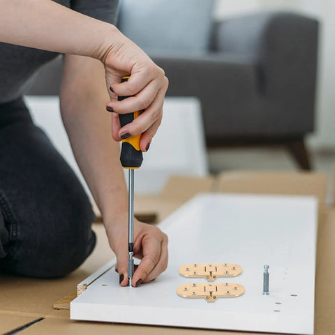 Installation of Brass Table Hinges 2-Piece Set for Butler Tray and Cabinet Furniture on white board using a screwdriver.