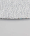 Close-up of 7 inch aluminum oxide sanding disc showing the textured surface for Grab These 50 Pack Super Tough 7 Inch Aluminum Oxide Sanding Discs With Hook Loop Backing And Flocking Design For Smooth Dry Sanding Projects No Clog Needed.