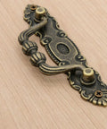 Close-up of Six Pack Vintage Antique Brass Bail Pulls for drawers, featuring zinc alloy with distressed finish and retro rustic hardware.