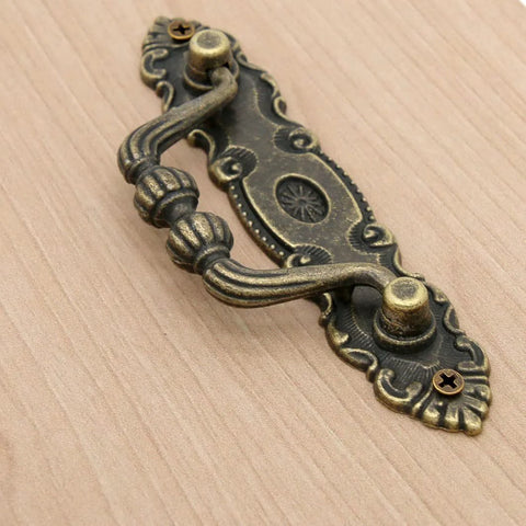 Close-up of Six Pack Vintage Antique Brass Bail Pulls for drawers, featuring zinc alloy with distressed finish and retro rustic hardware.