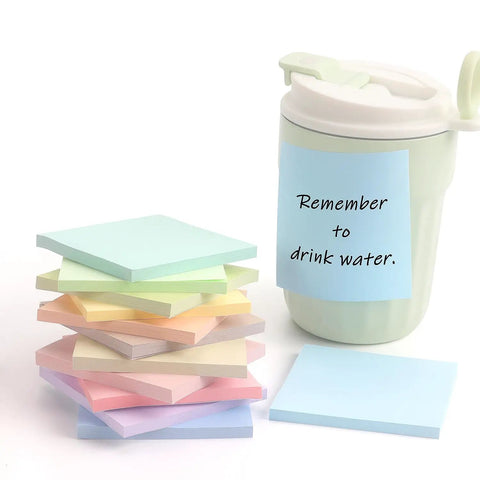 Pastel Sticky Notes 3 By 3 Inch 12 Pack With 50 Sheets Per Pad stacked next to a mug with a note reminding to drink water.