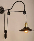Adjustable Iron Wall Sconce With Smooth Glide Pulley Wheel And Clear Glass Shade For Soft Cozy Ceiling Lighting mounted on beige wall.