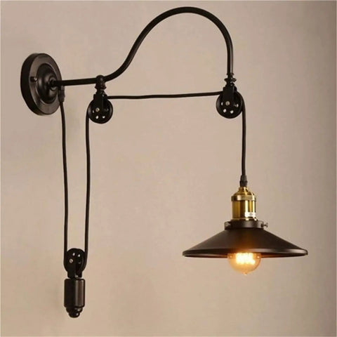 Adjustable Iron Wall Sconce With Smooth Glide Pulley Wheel And Clear Glass Shade For Soft Cozy Ceiling Lighting mounted on beige wall.