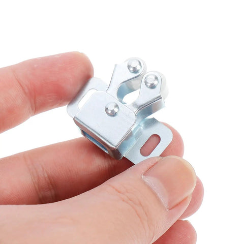 Close-up of Heavy Duty Cabinet Spring Catch Lock With Double Ball Rollers, cold rolled steel construction, held between fingers.